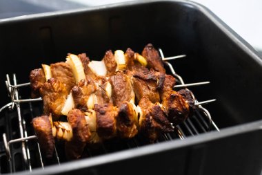 Fritözde pişmiş domuz kebabı. Shashlik. Kızartma makinesinde soğanlı marine edilmiş et parçaları..