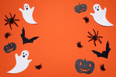 Turuncu arka planda balkabakları, örümcekler, yarasalar ve hayaletler. Cadılar Bayramı. Arkaplan ve sunumlar için