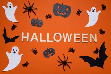 Cadılar Bayramı harfleri turuncu arka planda balkabakları, örümcekler, yarasalar ve hayaletlerle birlikte. Cadılar Bayramı. Arkaplan ve sunumlar için