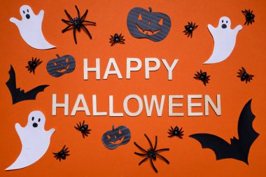 Turuncu arka planda balkabakları, örümcekler, yarasalar ve hayaletlerle dolu Cadılar Bayramı başlığınız kutlu olsun. Cadılar Bayramı. Arkaplan ve sunumlar için