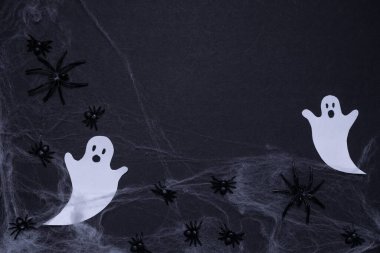 Siyah arka planda örümceklerle örümceklerle örümceklerle örülmüş hayaletler. Cadılar Bayramı. Arkaplan ve sunumlar için