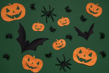 Yarasalar, balkabakları, yeşil arka planda örümcekler. Cadılar Bayramı. Arkaplan ve sunumlar için