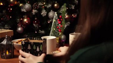 Noel günü hediye paketleyen bir kız. Yeni Yıl ve Noel