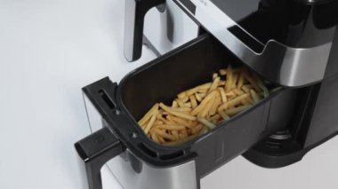 Açık hava fritöz çekmecesinin yakın çekim görüntüsü gevrek patates kızartmaları, yakınlaştırma efekti