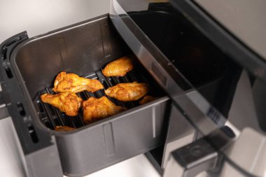 Kızartma sepetinde tavuk kanatları. Pişirdikten sonra, altın ve çıtır, servise hazır. 