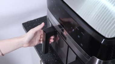 İçinde pizza dilimleri, kıtır kıtır ekmek ve erimiş peynir olan tava açıyorum.