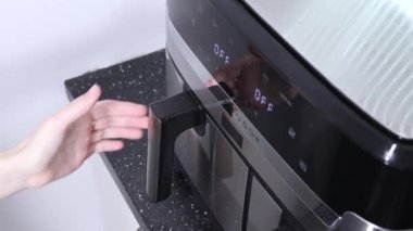 Izgara rafında tavuk kanatları olan bir fırın açmak, çekmeceyi çekmek...