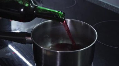 Sobanın tepesine kırmızı şarap dökerek. Sıcak şarap hazırlıyorum.