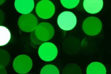 Koyu arkaplanda yeşil bokeh ışıkları, soyut tatil parıltısı, şenlikli atmosfer, yumuşak bulanık daireler, parlak dekorasyon, canlı efekt