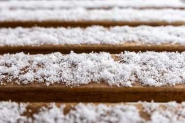 Tahtalarda karlı makro çekim, soğuk detaylar, kış dokusu, minimal tasarım, yakın plan perspektif, doğal güzellik, soğuk mevsim atmosfer, açık hava sahnesi