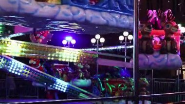 Ren geyiği figürleri ve tatil karakterleri, renkli ışıklar, şenlikli atmosfer, gece panayırı, dinamik hareket, Noel temalı cazibe, parlayan dekor