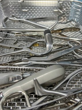 Metal tepside sterilize cerrahi aletler, tıbbi aletlere yakın çekim, parlak paslanmaz çelik, hastane hazırlığı.