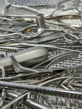 Sterilize edilmiş cerrahi aletlerin yakın çekimi, metal tepside paslanmaz çelik aletler, tıbbi prosedür için düzenlenmiş.