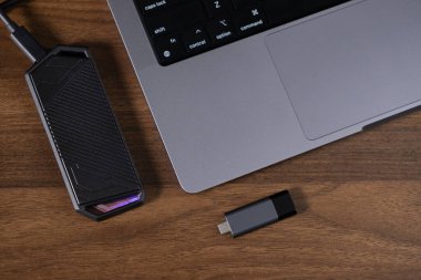 harici sssd sürücüsü ve USB flaş bellek ahşap masa, teknoloji ve veri depolama cihazları yanında