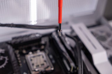vida tornavida, kırmızı saplı araç, bilgisayar montajı, yakın çekim görünümü, donanım kurulumu, hassasiyet çalışması, DIY PC kurulumu, teknik kurulum