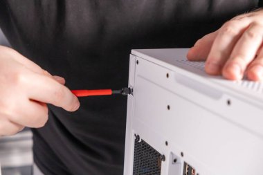 Bir bilgisayar dosyası oluşturuluyor, tornavida ile vidaları güvence altına alınıyor, yan panel kuruluyor