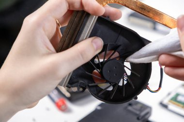 Gelişmiş termal yönetim için bakım sırasında dizüstü bilgisayar soğutma vantilatörü ve yumuşak bir bez ile ısıtma lavabosu