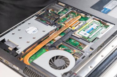 Sabit disk, RAM modülleri, soğutma vantilatörü ve ana kart da dahil olmak üzere iç bileşenleri gösteren açık bir dizüstü bilgisayar, onarıma veya bakıma hazır