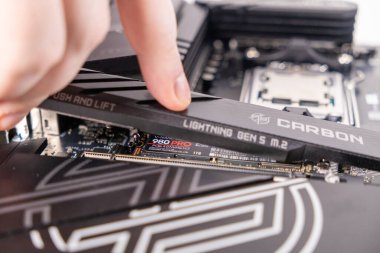 Poznan, Polonya - 25 Kasım 2024: teknisyen SAMSUNG 1TB M.2 PCIe Gen4 NVME 980 PRO SSD 'nin üzerine karbon ısıtıcısı yerleştiriyor, termal performansı artırıyor