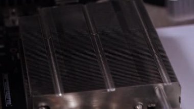 Cleaning CPU cooler heat sink using a specialized brush to remove dust and improve cooling efficiency for optimal PC performance