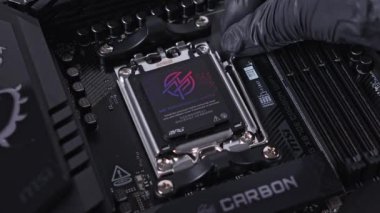 Poznan, Polonya - 25 Kasım 2024: MSI MPG X870E Karbon WiFi ana kart soketi açık koruyucu kapaklı, hassas raptiyeler sergiliyor