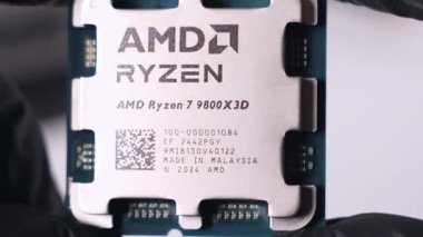 Poznan, Polonya - 25 Kasım 2024: Siyah eldivenlerde tutulan AMD Ryzen 79800X3D işlemcisinin yakın görüntüsü, model ayrıntıları ve üretim bilgileri