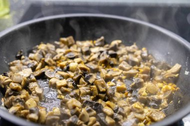 Kızarmış mantarlı tava ve sobada pişen soğan. 