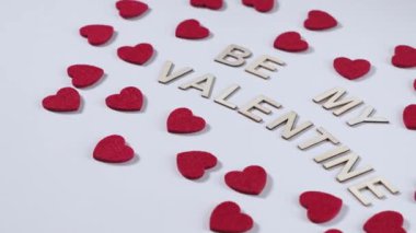 Ahşap harfler, beyaz arka planda kırmızı kalp süslemeleriyle çevrili benim VALENTINE 'ım olmak üzere ayarlandı. Romantik Sevgililer Günü ayarları.