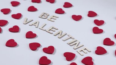 Beyaz arka planda kırmızı kalp süslemeleriyle çevrili 