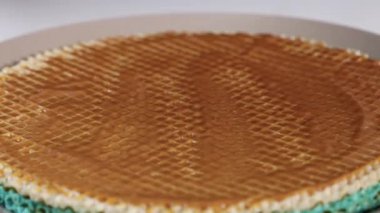 Bir sonraki waffle tabakasını karamel dolu bir tatlının üzerine koymak, tatlı bir ziyafetin montaj sürecini vurgulamak,