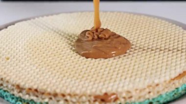 Karamelleştirilmiş yoğunlaştırılmış sütün waffle tabakalarına damlaması, tatlıya hazırlanma ve tatlı dokusunu ön plana çıkarması