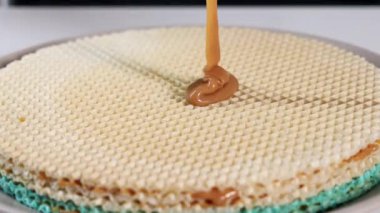 Karamelleştirilmiş konsantre sütü waffle tabakalarına dökmek, tatlıya hazırlanma ve tatlıya düşkünlüğü vurgulamak