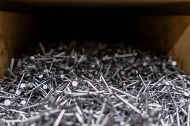 Bir hırdavatçıdaki depodaki gümüş çivi yığını inşaat için kullanılan metal bağlayıcıların yakın çekim görüntüsü.