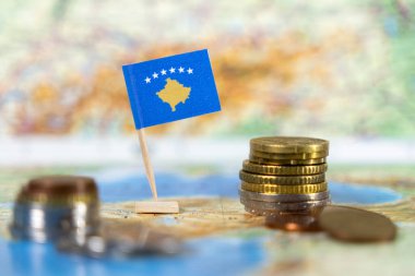 Dünya haritasında madeni paraları olan Kosova bayrağı, ekonomik ilerleme, mali kalkınma ve Avrupa entegrasyon çabalarını temsil ediyor 