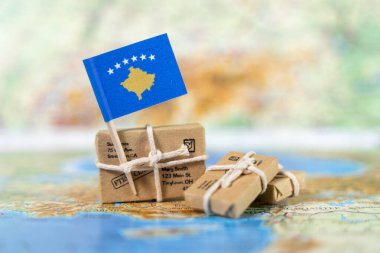 Uluslararası ticaret, ihracat ve küresel ticari bağlantıları sembolize eden, dünya haritasında bağlı paketler bulunan Kosova bayrağı