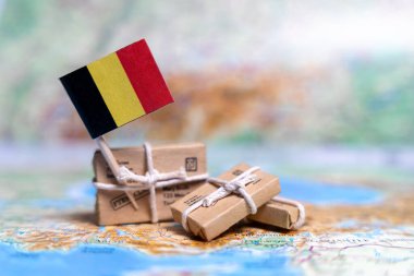 Dünya haritasındaki paketlerin yanında Belçika bayrağı var. Dünya ticareti. Mal ihracatı ve ithalatı. Ülkenin ekonomisi.