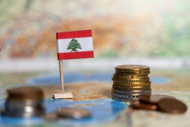 Lübnan 'ın ekonomisini, mali zorlukları ve Orta Doğu' daki ticaret fırsatlarını sembolize eden dünya haritasında sikkeleri olan Lübnan bayrağı
