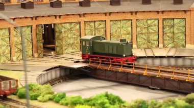 Minyatür Diesel Lokomotif Model Diorama 'da bir döner tablonun üzerinde döndükten sonra bir tren istasyonuna giriyor.