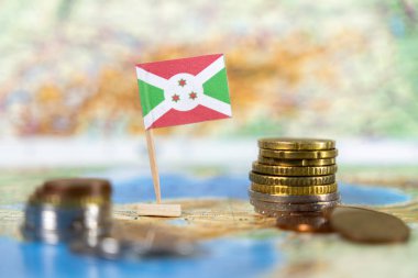Burundi bayrağı haritada madeni paralarla, bu Afrika ülkesindeki ekonomik zorlukları ve fırsatları sembolize ediyor ve gelişim ve sürdürülebilirliğe odaklanıyor.