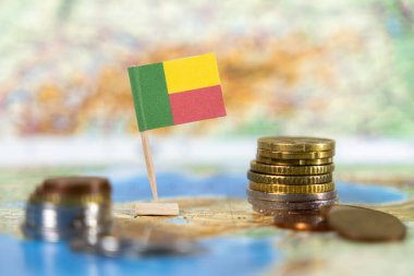 Ülkenin ekonomisini, mali kalkınmasını ve Batı Afrika 'daki ticaret potansiyelini sembolize eden, haritada sikke bulunan Benin bayrağı