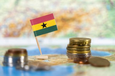 Batı Afrika 'da mali büyüme, ekonomik kalkınma ve ulusal gururu temsil eden dünya haritasında istiflenmiş sikkelerle dolu bir Gana bayrağı