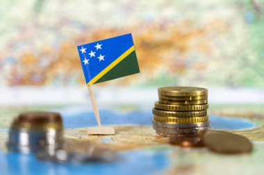 Süleyman adaları dünya haritasında sikkelerle bayrak çekerek, Pasifik bölgesindeki ekonomik kalkınmayı, finansal büyümeyi ve yatırım fırsatlarını sembolize ediyor.