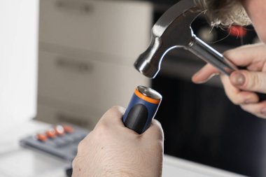 Adam çekiçle ev onarımı yapıyor. Atölyede ellere ve aletlere yakın çekim yapıyor.