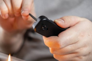 Yakın çekim eller plastiği ateşle eritiyor, ev projesini ısıtmalı metal aletlerle donduruyor.