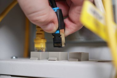 Ethernet kablosunu ağ portuna bağlayan teknisyen, İnternet kurulum sürecinin kapatılması, bilişim altyapısı ve teknoloji konsepti