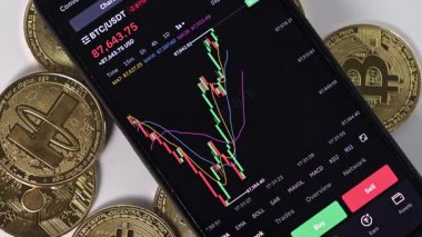 Poznan, Polonya - 7 Mart 2025: arkaplanda bitcoin, dijital ticaret ve yatırım kavramı bulunan akıllı telefon ekranında kripto para şeması taşınıyor