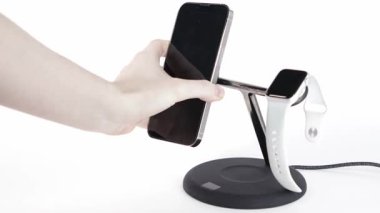 akıllı telefonu kablosuz şarj standına yerleştirmek beyaz arka plan, modern teknoloji konsepti ve akıllı aygıtlar üzerine akıllı twatch ile