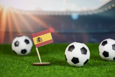 İspanya futbolu gururu yeşil sahada ulusal bayrak ve stadyumda futbol topları tutku, zafer ve spor mirasını simgeliyor.