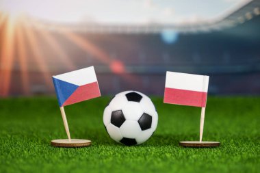 Czech cumhuriyeti, Polonya 'ya karşı ulusal bayraklarla futbol rekabeti, yeşil sahada futbol topu ve stadyum ışıkları, uluslararası rekabet ve tutkuyu simgeliyor.