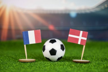 Fransa Danimarka 'ya karşı ulusal bayraklarla futbol maçı konsepti, yeşil sahada futbol topu, ve bulanık stadyum, uluslararası spor rekabetini ve birliği sembolize ediyor